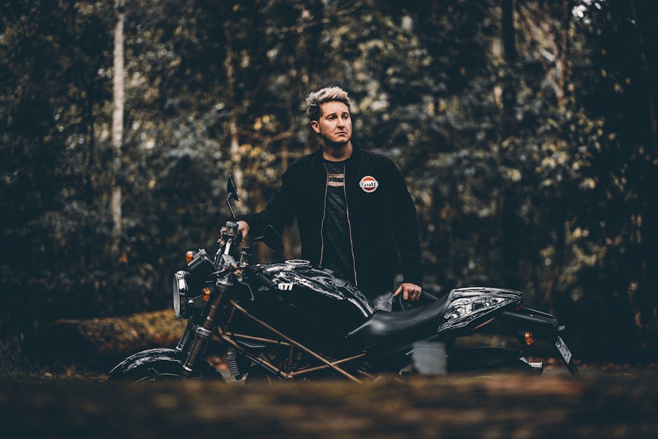 Man with a black vintage motorcycle in a forest, Gold Coast, Australia.
