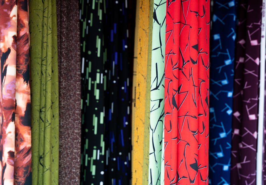 Vibrant rolls of patterned fabric on display at a market in Vietnam. Perfect for textile and design inspiration.