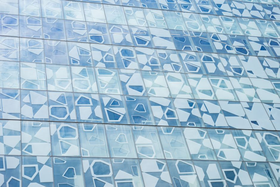 Contemporary building facade featuring abstract geometric shapes on glass panels.