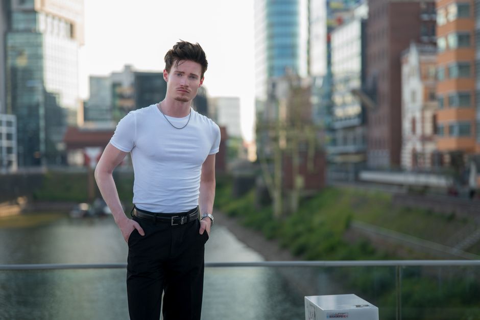 Portrait of a young man in Düsseldorf, Germany, with modern architecture.