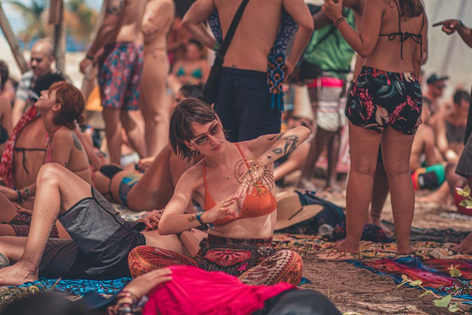 Lively beach gathering with people enjoying summer vibes and colorful attire.