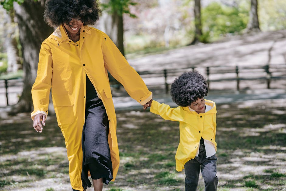 A mother and child enjoy a sunny day wearing stylish matching yellow raincoats.