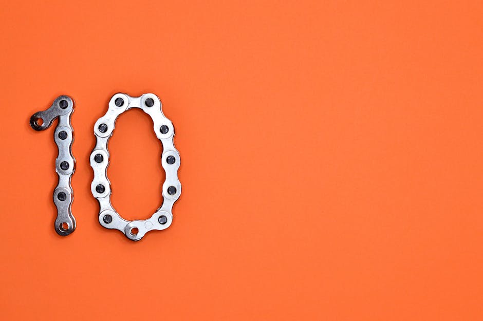 Bicycle chain arranged to form the number ten against a bright orange background.