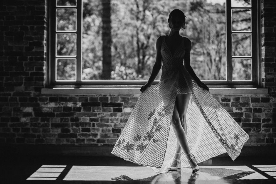 Beautiful silhouette of a bride in a lacy gown by a window in Gramado, Brazil.